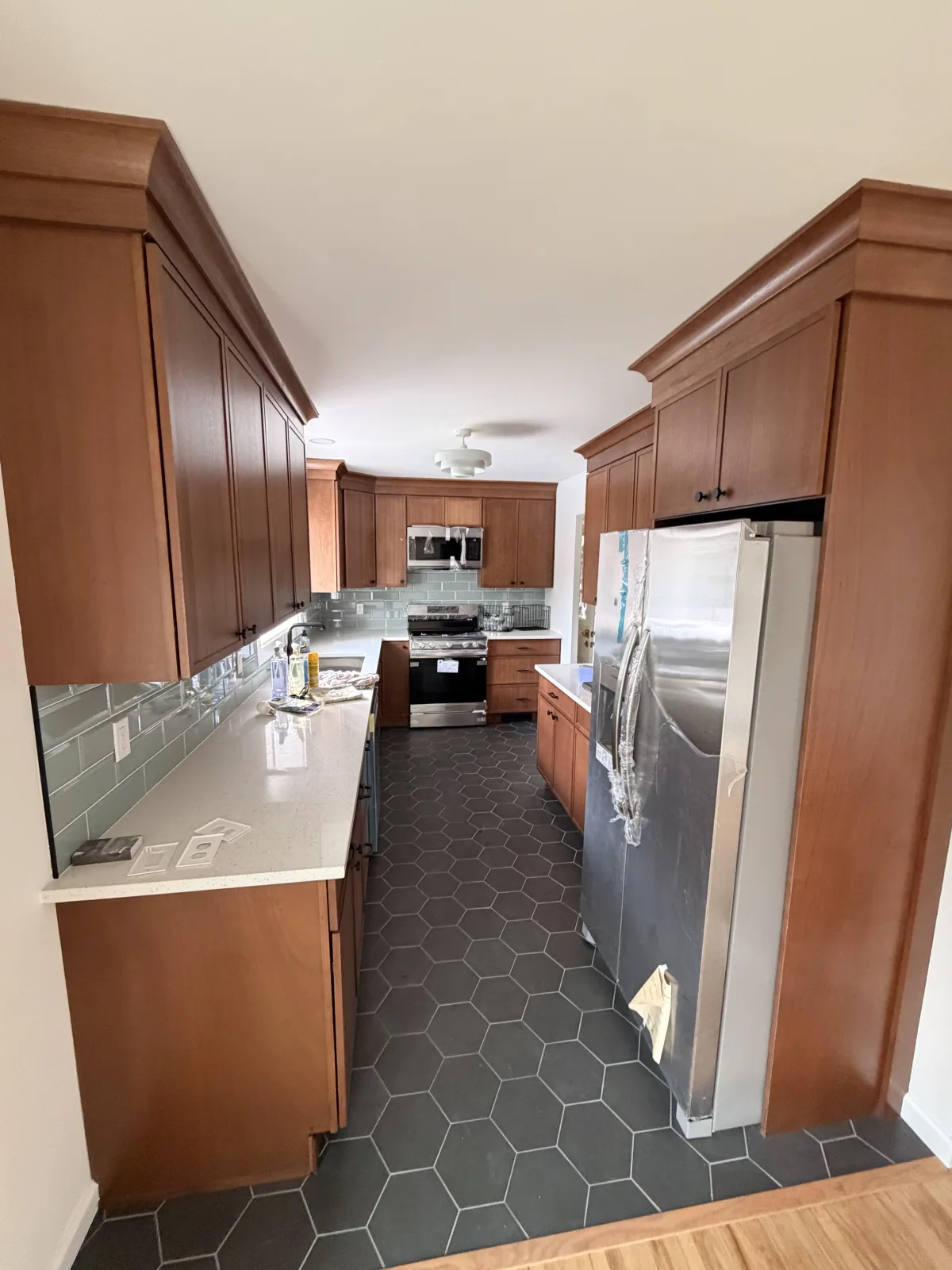 Kitchen with cherry cabinetry and a dark hexagonal tile floor