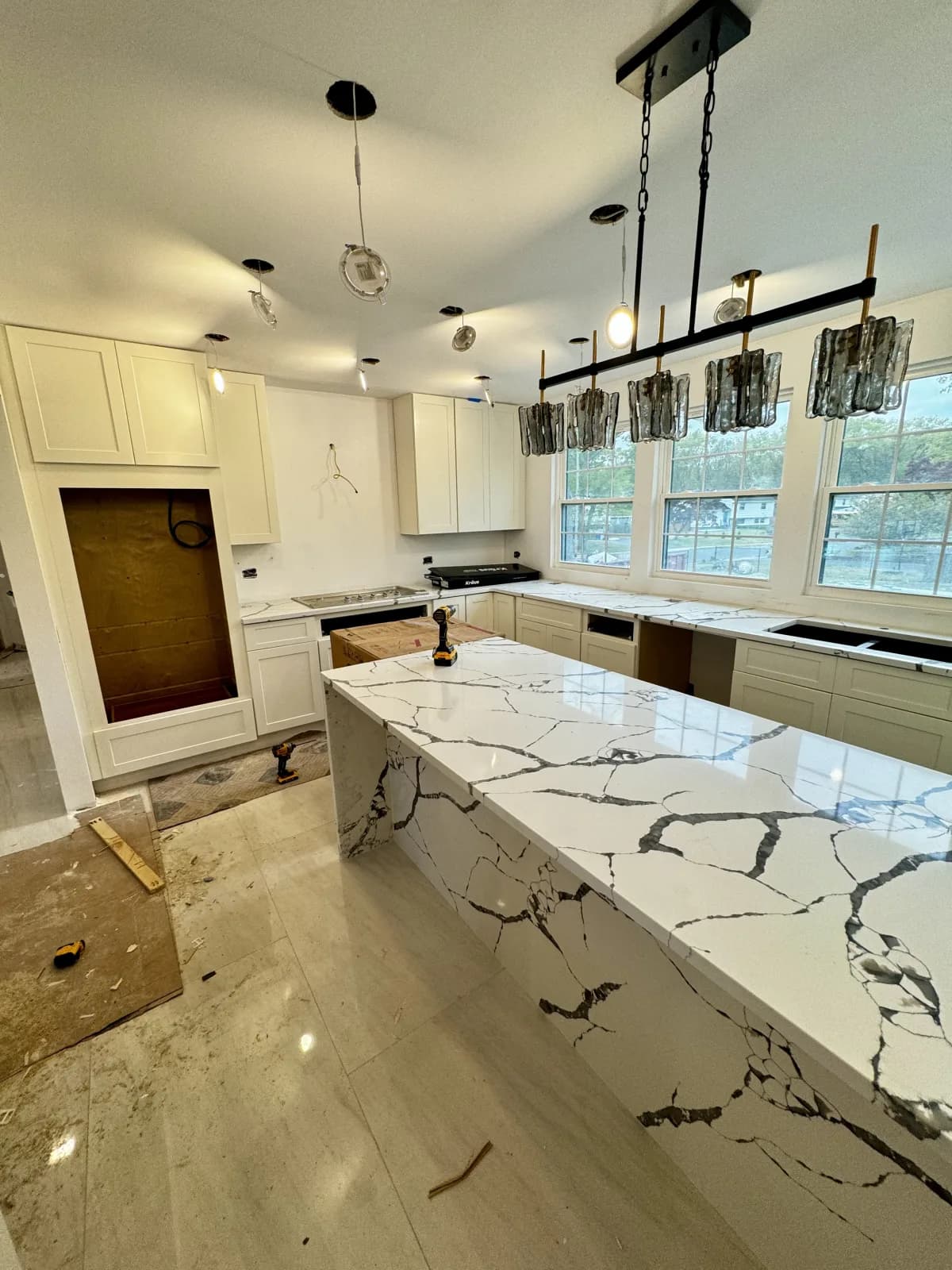 Kitchen island with a waterfall marble countertop and custom cabinetry