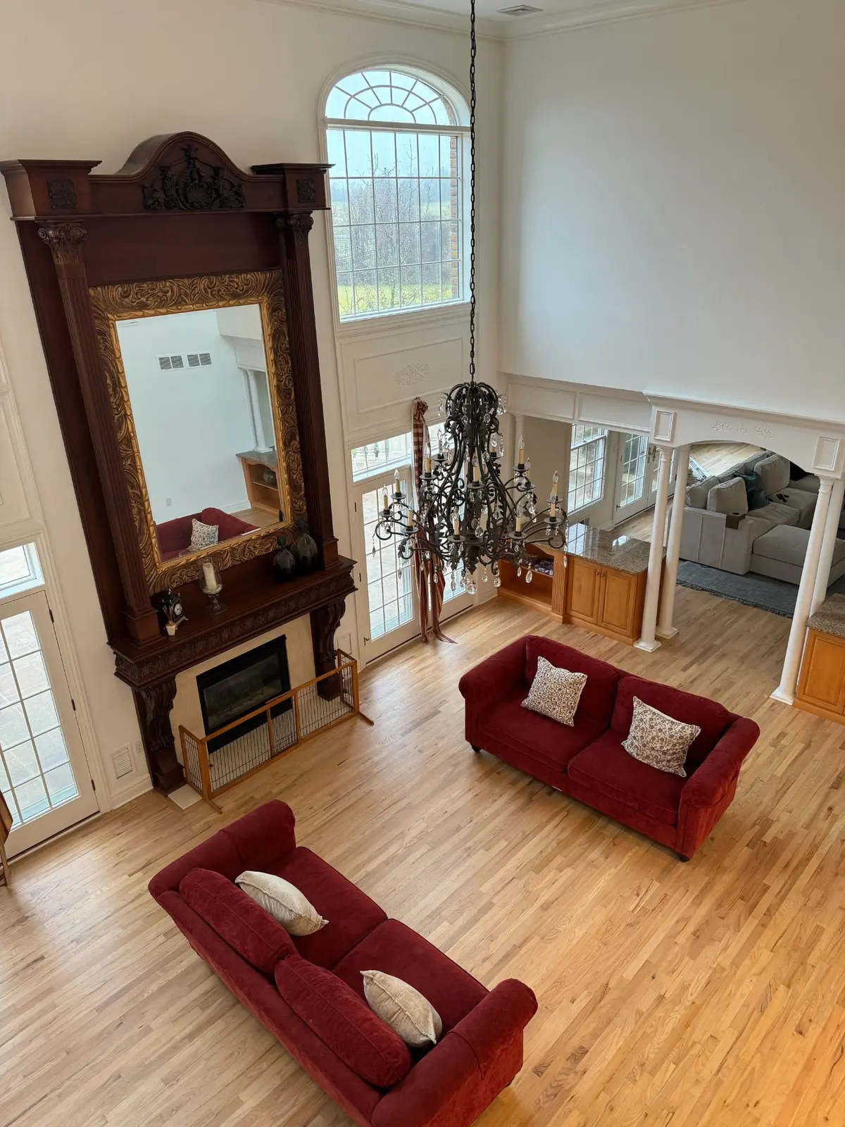 Refinished hardwood floors in a furnished living room with a formal entry