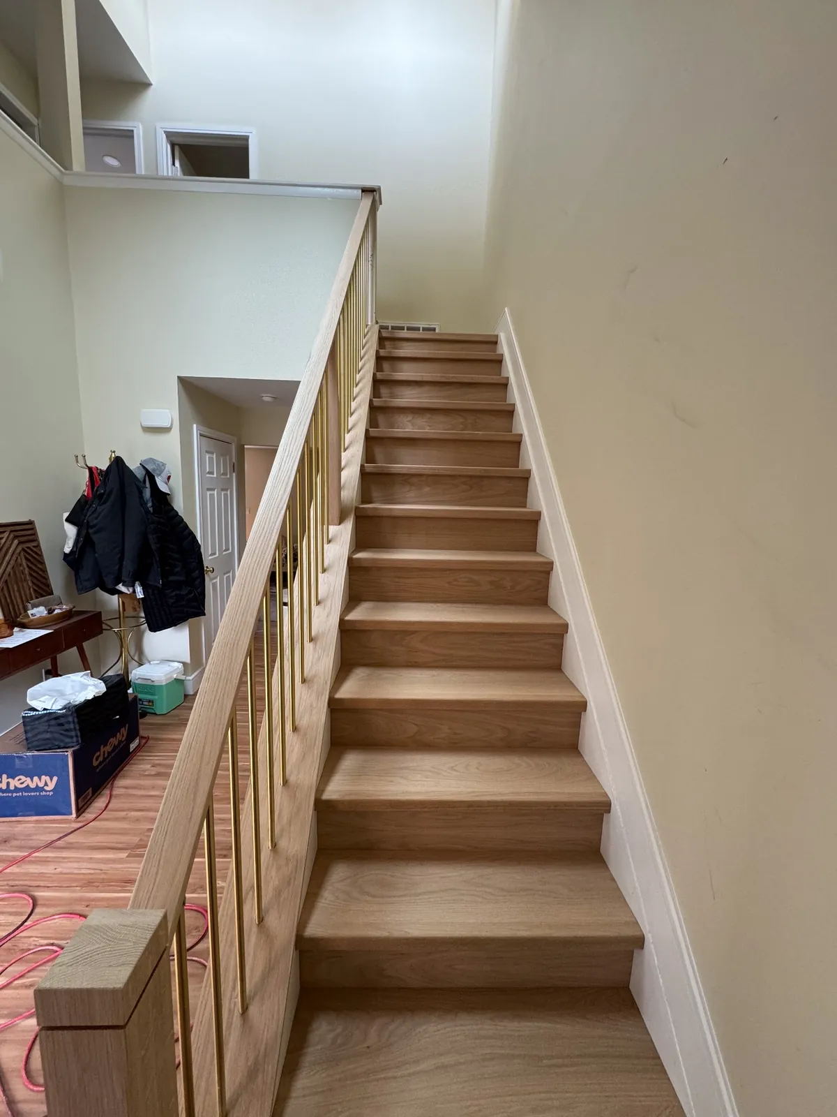 Oak staircase with wooden balusters rising from a tiled entryway