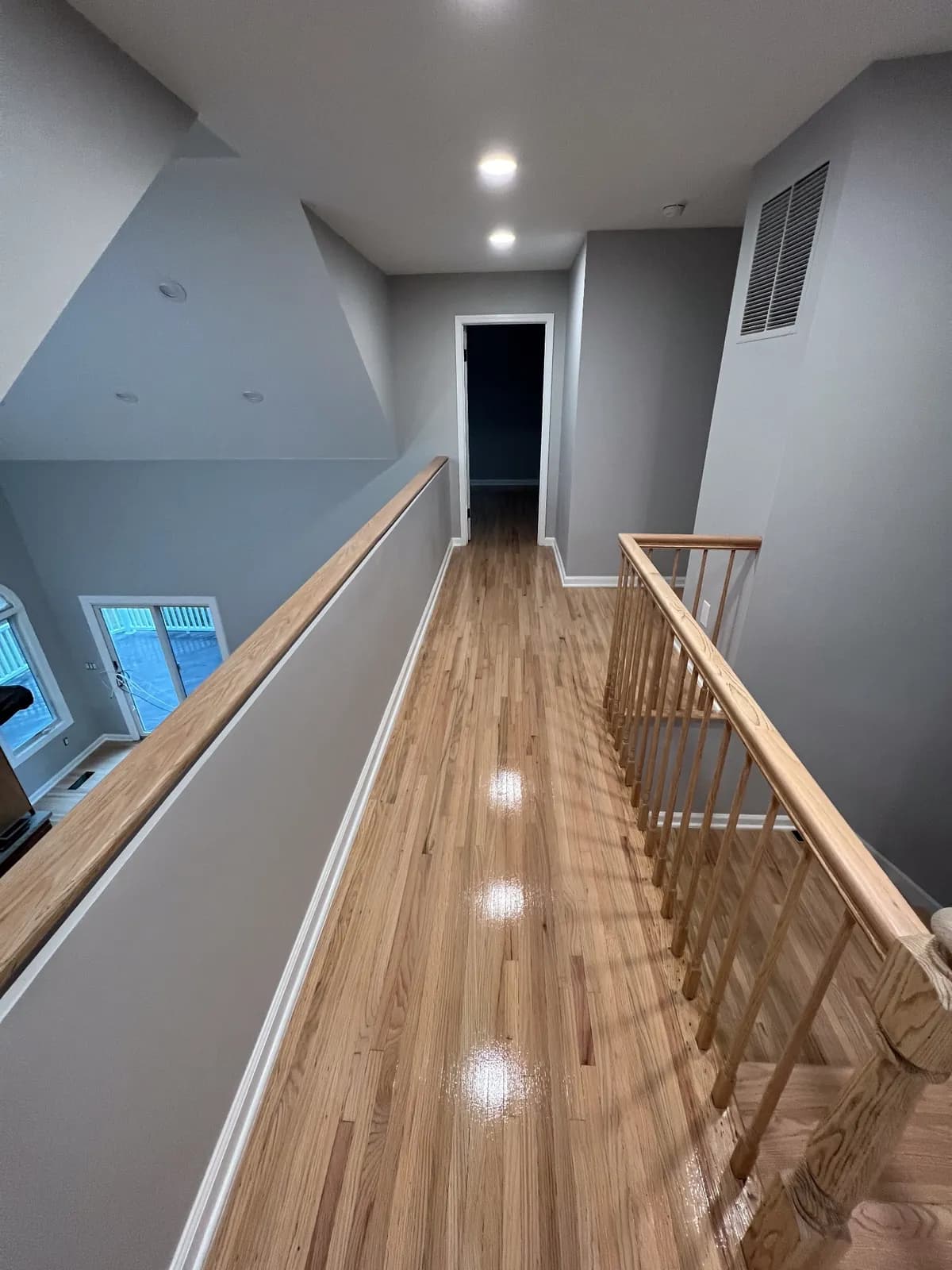Upstairs landing with an oak floor and a wooden gallery railing