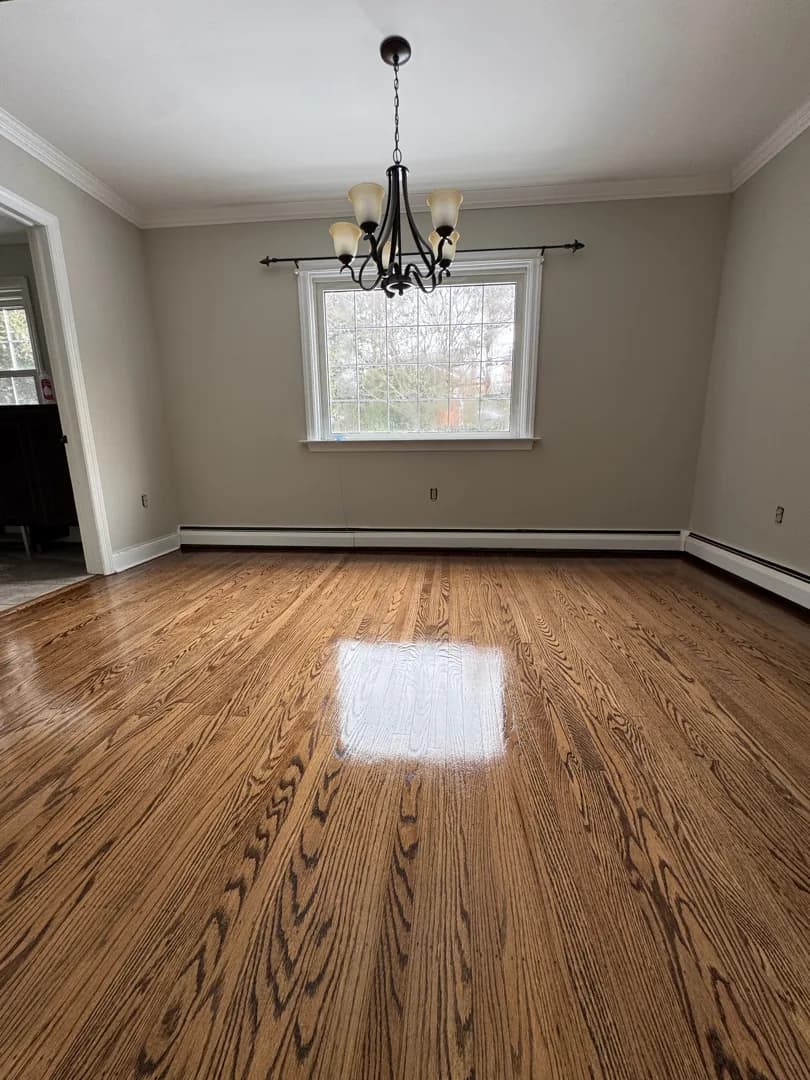 Dining room with a refinished red oak floor under a wrought-iron chandelier