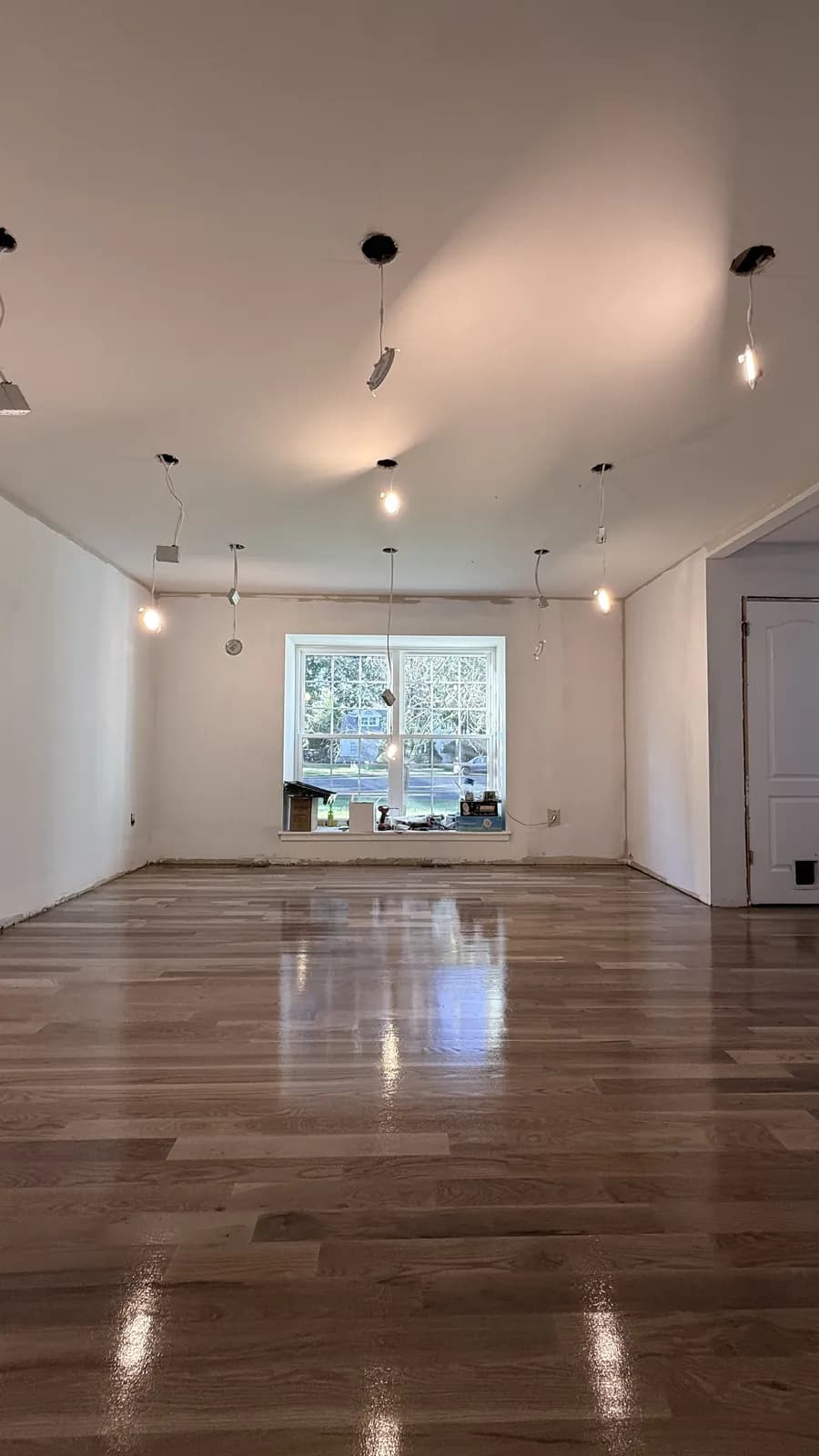 Long room with a dark-stained oak floor under exposed track lighting