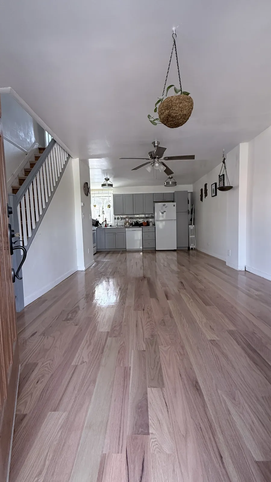 Pale oak hallway leading past a staircase into a kitchen