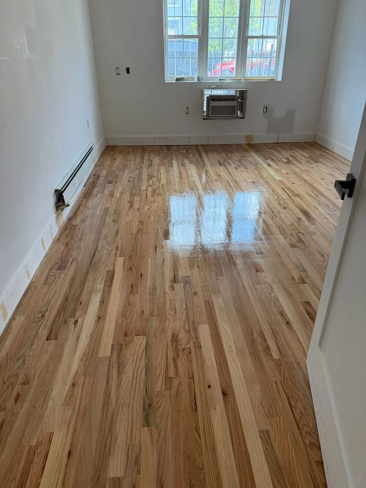 Strongly grained refinished oak floor in an empty room