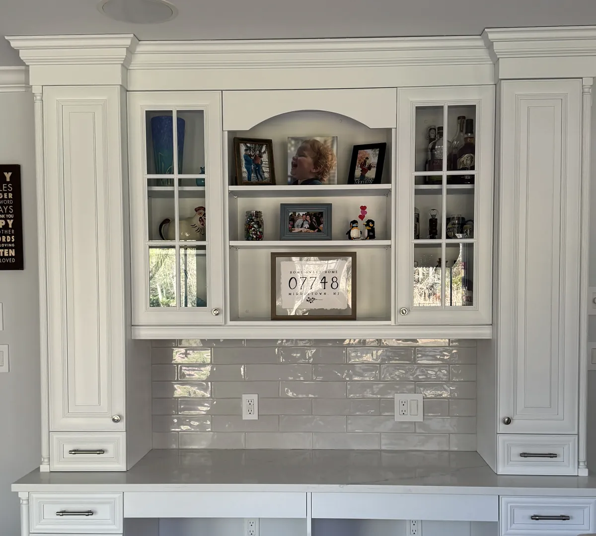 After: the same built-in, painted white, with a glazed white subway tile backsplash above the desktop, by Summit Home Services