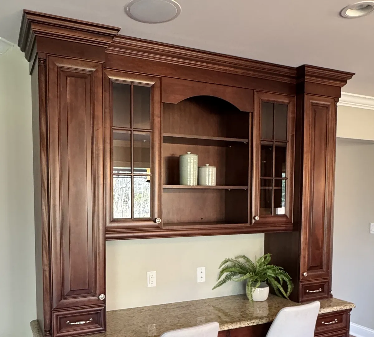 Before: a cherry built-in desk unit with a painted wall and no tile above the granite desktop