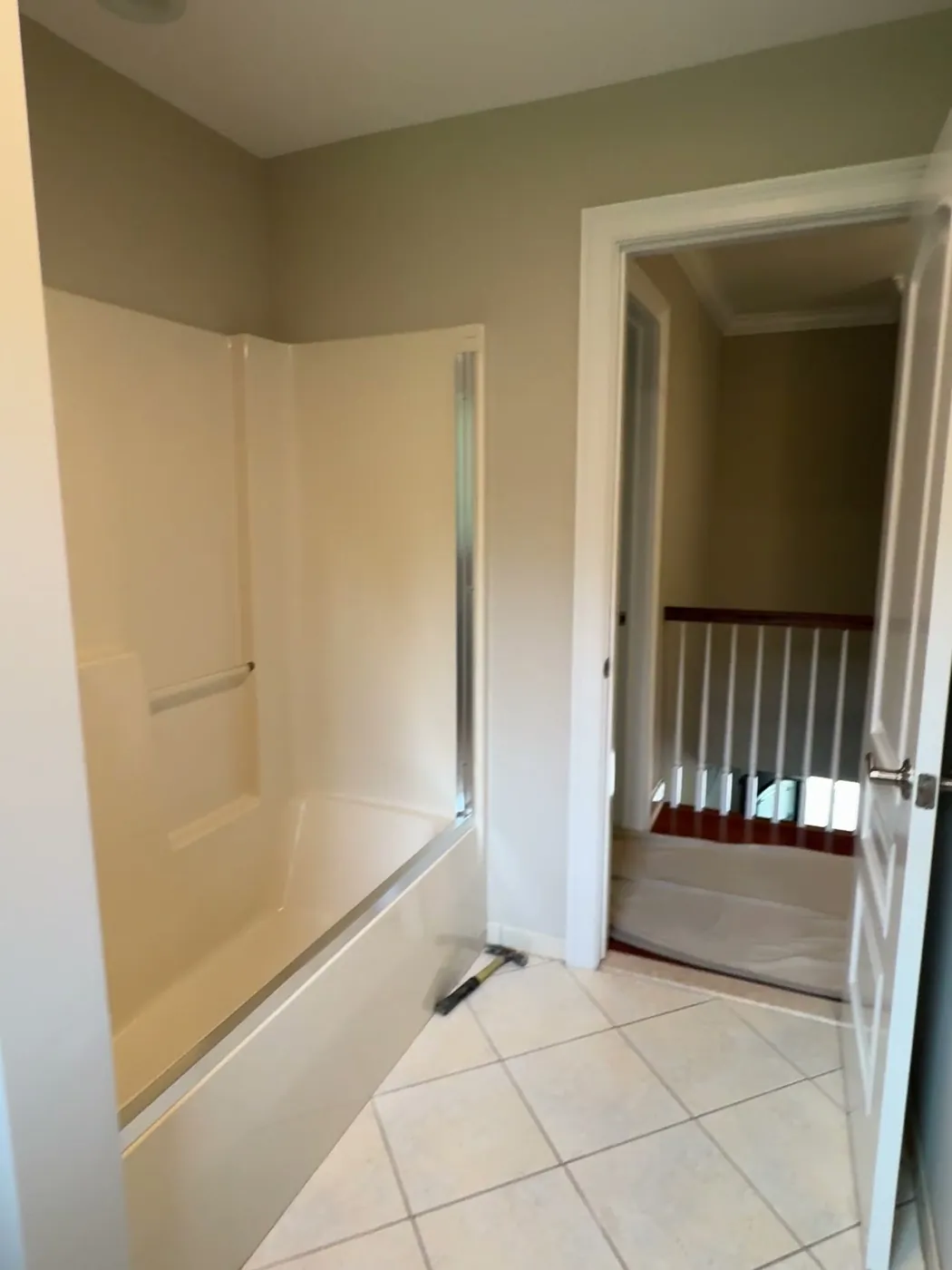 Before: a fiberglass tub surround and diagonal white floor tile in a Middletown NJ bathroom